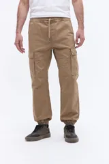 Pantalón cargo de corte relajado color tostado, con cintura elástica y cordón ajustable, bolsillos laterales tipo cargo y puños elásticos en los tobillos.