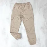 Pantalón cargo color beige de nylon con puño elástico en los tobillos.
