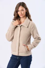 Campera de sherpa color beige con cierre frontal de botones a presión y cuello camisero. Presenta un diseño de textura afelpada con detalles de ribetes en la solapa y puños.
