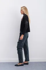 Pantalon cargo de corte recto y tiro medio, confeccionado en gabardina elastizada. Presenta bolsillos laterales tipo cargo, cierres metálicos en la botamanga y cinturón interno ajustable con hebilla.