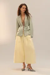 Zapato de tacón con cuerpo cubierto de lentejuelas plateadas, diseño con tira en T, cierre de hebilla en el tobillo y acabado en punta.