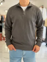 Buzo de punto gris oscuro con cuello alto y medio cierre frontal, mangas largas y puños y cintura de rib elástico.