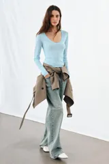 Top de punto extrafino color celeste, con escote redondo y manga larga.