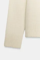 Jersey de punto liso con cuello redondo y manga larga, con acabados en rib en puños y ruedo.