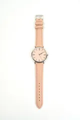 Reloj de pulsera con correa de cuero sintético rosado, caja plateada y esfera analógica minimalista.