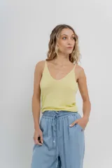 Top de breteles finos con escote en V, confeccionado en tejido de punto con lúrex que aporta un brillo sutil. Presenta un calce ajustado y versátil.