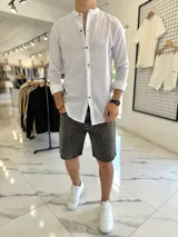Camisa de lino blanca con finas rayas negras, cuello mao y cierre frontal con botones de madera.