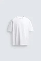 Camiseta de corte relajado confeccionada en algodón con textura irregular, cuello redondo y manga corta.