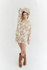 Sweater oversize con cuello en V y estampado de rombos en tonos lila, rosa y rojo. Tejido de lana artesanal.