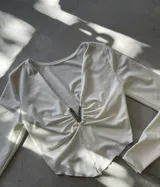 Top marrón de mangas largas con escote en V y detalle de strass en el centro.