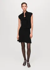 Falda corta de tejido tweed en color negro, con diseño entallado y terminaciones deshilachadas en el ruedo.