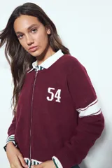 Campera de punto tipo cardigan en color bordó, con cierre frontal, cuello redondo y diseño estilo universitario. Presenta el número 54 bordado en blanco en el pecho y franjas blancas en las mangas.
