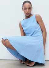Vestido corto celestes sin mangas, con cuello barco y diseño de tablas en la falda. Cuenta con tirantes anchos, cierre de cremallera en la parte posterior y forro interior.