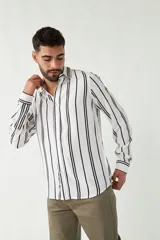 Camisa de mangas largas con estampado a rayas verticales en tonos verde oliva, blanco y azul. Corte regular y logo bordado en el pecho. Confeccionada en viscosa.