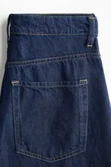 Jean wide leg de tiro alto en denim azul oscuro, de cinco bolsillos, confeccionado en mezcla de algodón y lyocell.