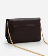Cartera bandolera pequeña de poliuretano color marrón oscuro con acabado texturizado. Cuenta con solapa frontal, logo metálico dorado en la parte inferior y correa larga de cadena metálica dorada.