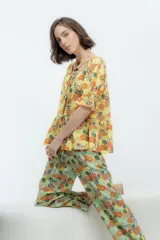 Camisa estampada con flores, de lino o popelina, con cuello en V y mangas cortas con volados. Se cierra con lazos en el frente.