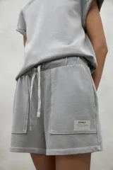 Shorts grises con cintura elástica ajustable y bolsillos laterales.