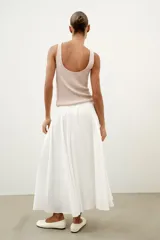 Top de punto canalé en color beige, con escote en pico adornado con una delicada aplicación de encaje blanco y tirantes anchos.