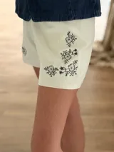 Short elastizado color marfil con delicados bordados de flores en tono azul marino en la parte frontal.