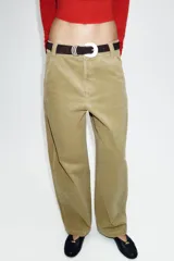 Pantalón de tiro alto confeccionado en pana, con diseño de pernera holgada que se estrecha hacia el tobillo. Presenta bolsillos delanteros, bolsillos de plastrón en la parte trasera, costuras marcadas en el frente y cierre frontal con cremallera y botón.