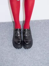 Mocasines con plataforma de goma negra, confeccionados en lona con estampa a cuadros en tonos violeta, amarillo y beige, y detalle de elásticos laterales ocultos.