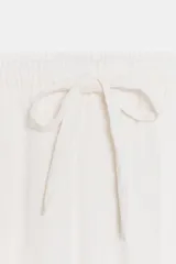 Pantalón celeste de tiro medio con bolsillos delanteros y traseros. Cintura elástica ajustable con cordones.