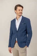 Saco de jersey de algodón en color azul, con corte custom fit, cierre frontal de botones y bolsillo en el pecho con pañuelo estampado.