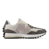 Championes New Balance modelo 327, con diseño inspirado en los años 70. Presentan una combinación de tonos grises, beige y blanco, con el logo 'N' característico en el lateral. Confeccionados en cuero y nailon, cuentan con una suela con relieve inspirada en el trail y cierre con cordones.