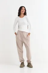 Pantalón jogger de felpa color marrón, con cintura elástica ajustable mediante cordón, bolsillos laterales y puños elásticos en los tobillos.