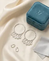 Caravanas de plata 925 con diseño de aro trenzado y dijes colgantes en forma de lágrima con cristales transparentes.