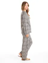 Conjunto de pijama compuesto por una remera de manga larga con escote en V, abertura frontal con botones y bolsillo aplicado, y un pantalón con cintura elástica y lazo de ajuste. Presenta un estampado animal print en tonos neutros.