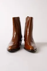 Bota de cuero negro estilo texano, con caña media, elástico lateral con costuras verticales y taco cuadrado.