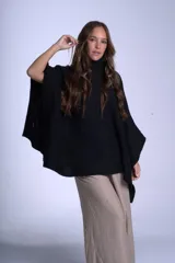 Poncho tejido color beige, con cuello alto y corte asimétrico.