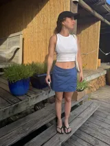 Falda corta tipo pareo de lino, color azul, con diseño cruzado y ajuste lateral.