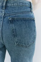 Jeans de tiro alto con corte recto y largo completo. Presenta diseño de cinco bolsillos, trabillas en la cintura y cierre frontal con cremallera y botón, con un acabado de efecto lavado.