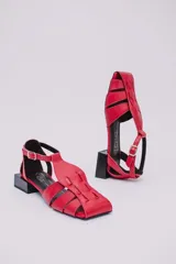 Sandalias de cuero estilo jaula en color rojo, con punta cuadrada, taco cuadrado bajo en color negro y cierre con hebilla ajustable en el tobillo.