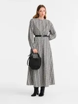 Cartera de mano tamaño pequeño Longchamp de la línea Le Foulonné, confeccionada en cuero negro con diseño estructurado de forma semicircular, asa superior y correa ajustable.