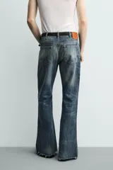 Jeans flare fit de tiro medio, confeccionados en denim de algodón color azul con efecto deslavado. Diseño ajustado en la parte superior y abierto en campana desde la rodilla, con cinco bolsillos y cierre frontal con cremallera y botón.