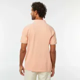 Remera polo de piqué color naranja con cuello y mangas con borde blanco.