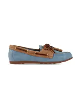 Mocasín estilo náutico confeccionado en cuero y gamuza, en tono celeste y detalles marrón tostado, con cordones de cuero, ojales metálicos dorados y borlas decorativas en el empeine.