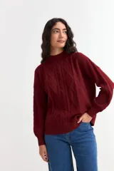 Sweater de punto color bordó con diseño de ochos, cuello redondo y mangas largas con puños acanalados.
