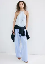 Pantalón de corte recto y tiro bajo, de diseño amplio y fluido, con patrón de rayas verticales finas.