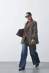 Blazer de corte relajado con estampado de cuadros tipo pied de poule en tonos rojizos y verdes. Presenta solapas clásicas en color azul oscuro y estructura definida.