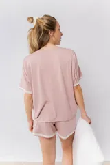 Pijama de algodón compuesto por una remera de cuello redondo y mangas cortas con detalle de puntilla, y un short con cintura elástica y ruedo con puntilla.