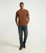 Remera de manga corta y cuello redondo, confeccionada en tejido de media malla con textura vertical. Presenta un diseño minimalista y ligero, ideal para un uso versátil y cómodo.