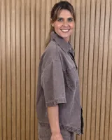 Sobrecamisa de denim soft color beige, con cuello camisero, mangas cortas amplias, bolsillos frontales con solapa y cierre de botones metálicos.