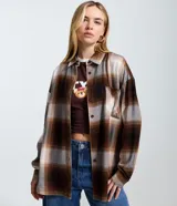 Camisa de manga larga confeccionada en franela de viscosa, con estampado de cuadros en tonos marrones, beige y gris. Presenta cuello clásico, cierre frontal con botones y bolsillo en el pecho.