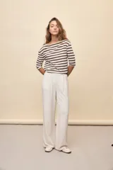 Pantalón negro de pierna ancha y calce fluido, con pinzas delanteras y bolsillos laterales.