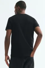Remera de punto liviano color negro, con cuello redondo y mangas cortas. Diseño slim fit de corte entallado y bajo recto.